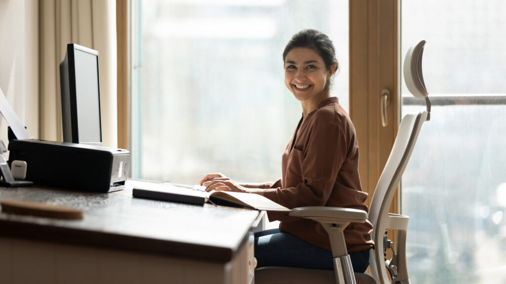 Colaboradora de uma empresa senda na posição correta como após o serviço de ergonomia da Glaboral